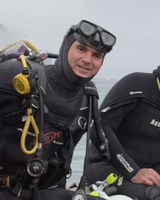 Cristóbal Cordero con traje de buceo en una embarcación